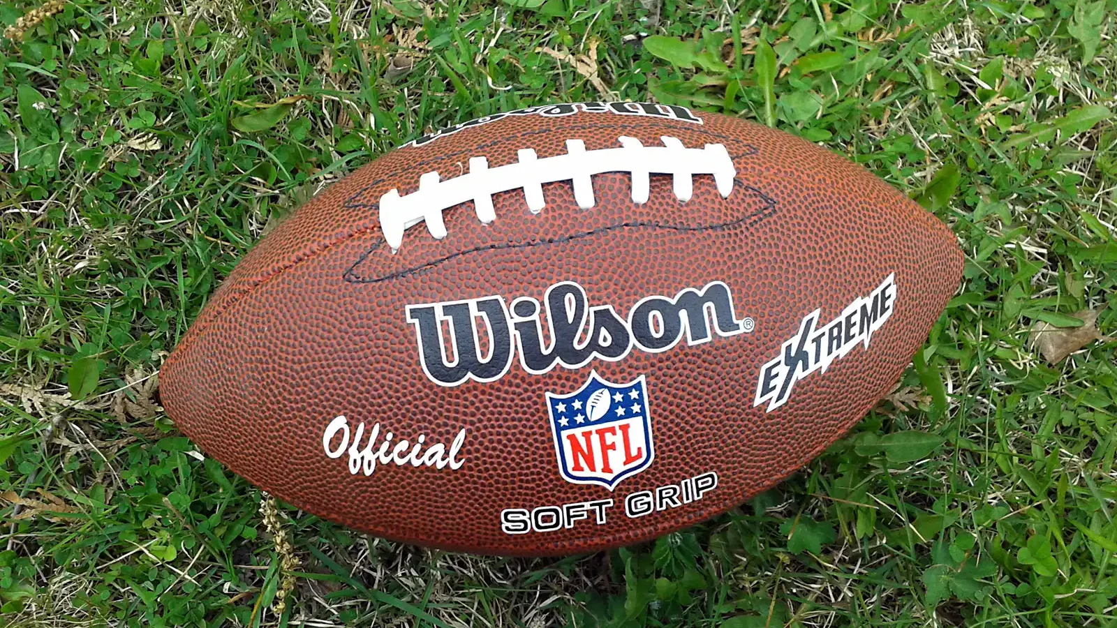 Un ballon ovale de football américain posé au sol